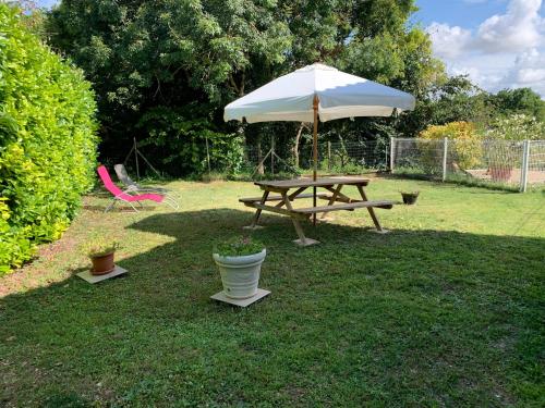 a picnic table and an umbrella in a yard at maison avec jardin et parking privé in Meschers-sur-Gironde