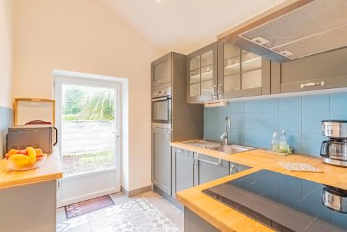 une cuisine avec un évier et un plan de travail dans l'établissement Tikaz Rolè - Maison de pêcheur, à Pleumeur-Bodou