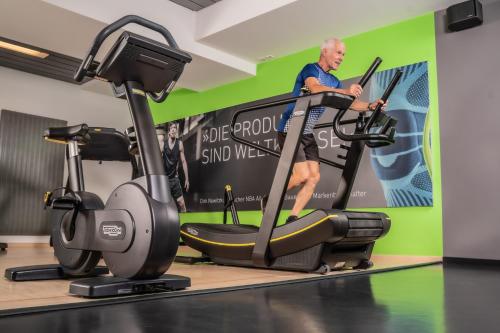 a man on a treadmill in a gym at Bio-Seehotel Zeulenroda in Zeulenroda