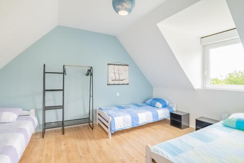 a white room with two beds and a window at Tikaz Rolè - Maison de pêcheur in Pleumeur-Bodou
