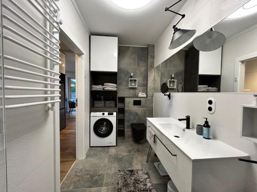 a bathroom with a sink and a washing machine at Apartament z ogródkiem in Piła