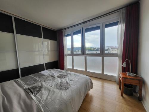 um quarto com uma cama e uma grande janela em Spacious Apartment near Paris, for Family and Friends em Montrouge