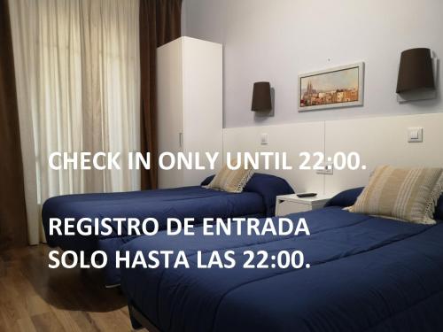 Un dormitorio con 2 camas y un póster para un hotel en Hostal Lesseps, en Barcelona