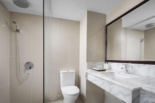 a bathroom with a toilet and a sink and a shower at Ohana Phnom Penh Palace Hotel in Phnom Penh