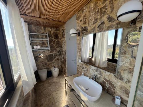 a bathroom with a sink and a stone wall at Il Dammuso di Noto - Villa con Piscina privata in Avola