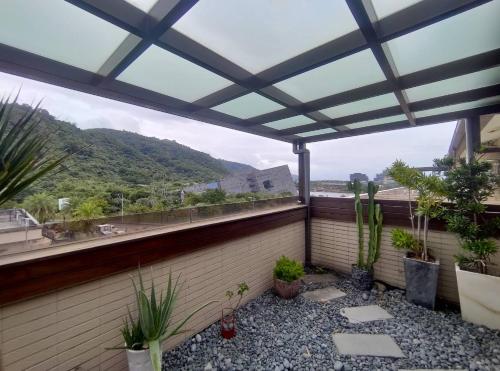 a patio with a roof with plants on it at Ciao Home in Toucheng