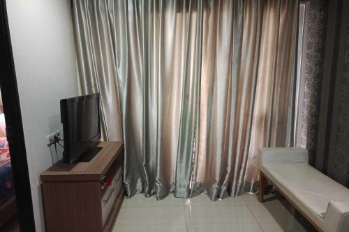 Cette chambre dispose d'une télévision et d'un rideau. dans l'établissement MyStayPro Sentra Timur, à Jakarta