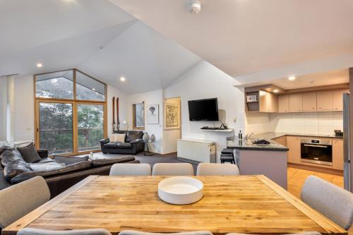 a kitchen and living room with a wooden table at Lhotsky 4 in Thredbo