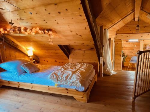 Belle maison chaleureuse, lumineuse dans la nature في Eygliers: غرفة نوم بسرير في كابينة خشبية