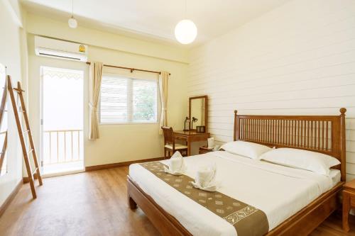 una camera con un grande letto e una finestra di Tini Kati Hostel a Bangkok