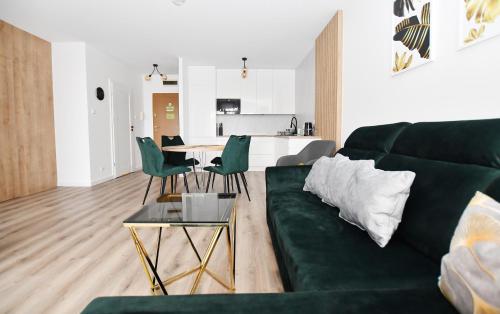 salon z zieloną kanapą i stołem w obiekcie Apartamenty NAVIGATOR-Rezydencja Portowa 14 w Kołobrzegu