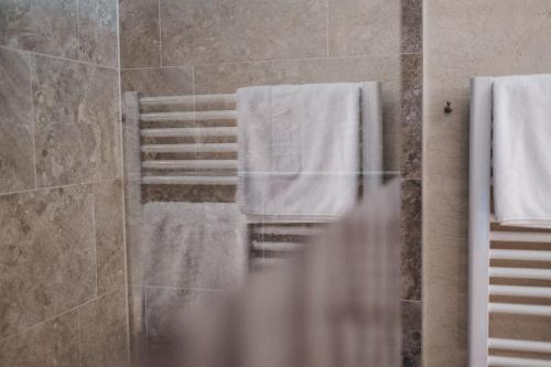 a bathroom with white towels hanging on a wall at Hotel Chesa Monte 4Sterne Superior in Fiss