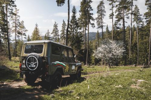 a green jeep parked on a dirt road at Gold Infinity in Velingrad