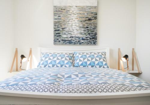 Un dormitorio con una cama con almohadas azules y blancas. en Happy Valley, en Rye