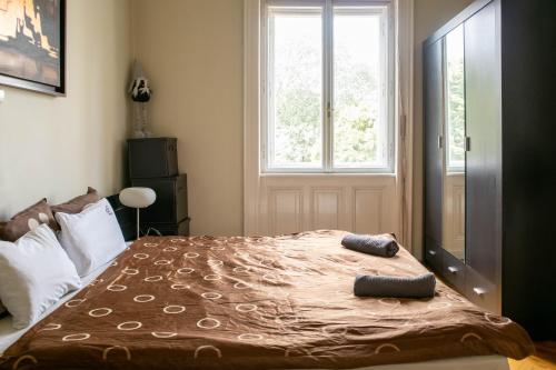 a bedroom with a large bed in front of a window at d.Five Döbrentei Apartment in Budapest