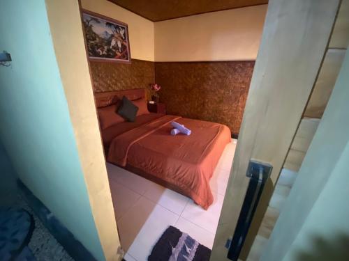 a bedroom with a red bed with a teddy bear on it at D'Yoga Bamboo House in Kintamani