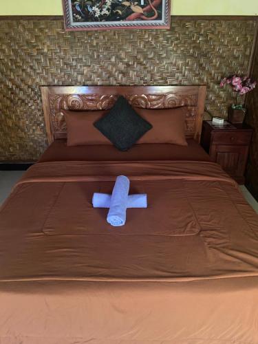 a blue towel sitting on top of a bed at D'Yoga Bamboo House in Kintamani