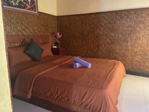 a bedroom with a large bed with a purple teddy bear on it at D'Yoga Bamboo House in Kintamani