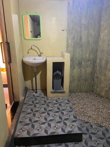 a bathroom with a sink and a mirror at D'Yoga Bamboo House in Kintamani