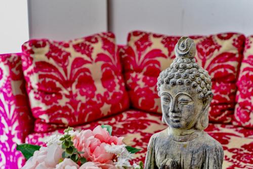 a statue in front of a couch with red pillows at Buda Bliss Garden in Budapest