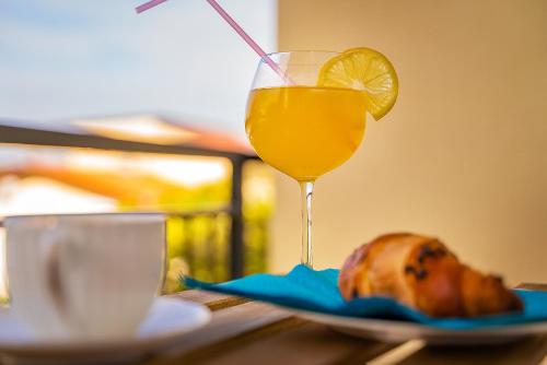 a glass of orange juice next to a plate of food at Apartment Noa Malinska in Vantačići