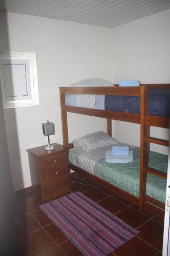 a bedroom with two bunk beds and a night stand at CasaTioManel in Amiães de Baixo