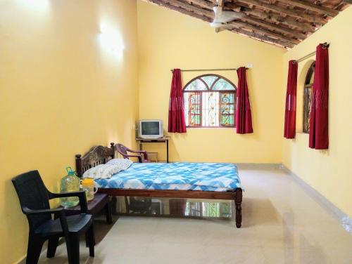 a bedroom with a bed and a table and a window at The Grace Guest House in Salcete