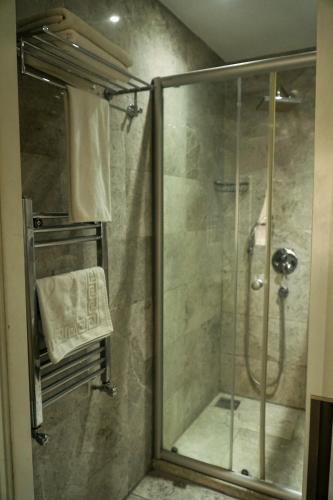 a shower with a glass door in a bathroom at En Otel Karaca in Eskisehir