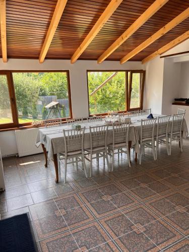 a dining room with a long table and chairs at Pensiunea Poiana Luminoasă in Bughea de Jos