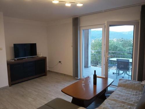 - un salon avec un canapé et une table avec une télévision dans l'établissement Valentina, à Vinišće
