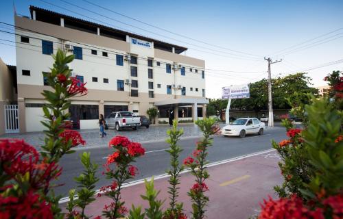 a building with cars parked on the side of a street at Hotel Rekinte in Aracaju