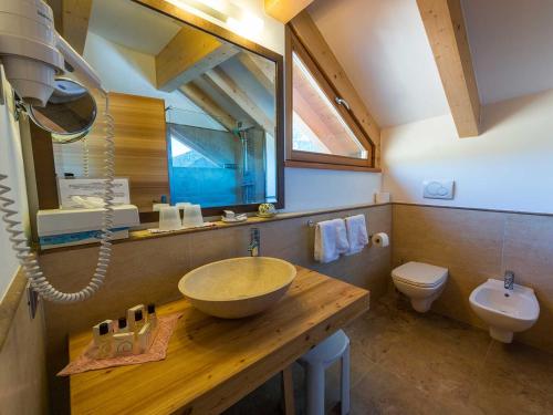 La salle de bains est pourvue d'un lavabo et de toilettes. dans l'établissement Bio Hotel Brusago Vital & Wellness, à Bedollo