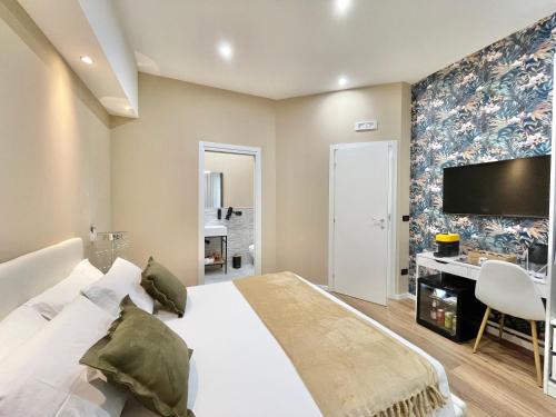 a bedroom with a large white bed and a desk at Regina Elena Rooms in Pescara