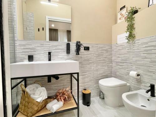 a bathroom with a sink and a toilet and a mirror at Regina Elena Rooms in Pescara
