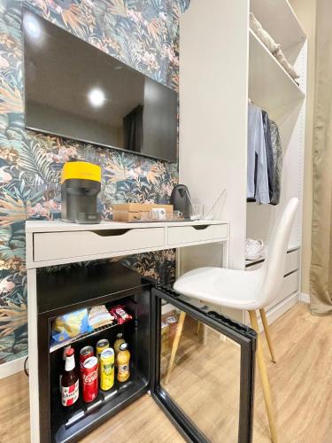 a desk and a chair in a room with a refrigerator at Regina Elena Rooms in Pescara