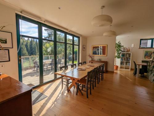 a large dining room with a long table and chairs at Glenardle Lodge in Bridge of Cally