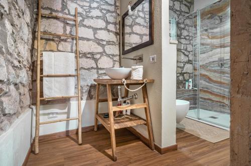 ein Bad mit einem Waschbecken und einer Glasdusche in der Unterkunft La Tabarchina - Carloforte Lovely Apt With Terrace! in Carloforte