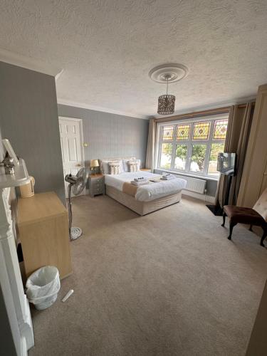a bedroom with a bed and a large window at The Six Bells in Rochester
