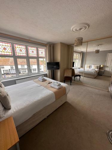 a bedroom with a large white bed in a room with windows at The Six Bells in Rochester