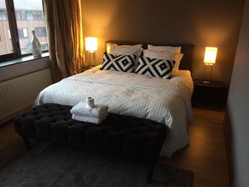 a bedroom with a large bed with a black ottoman at Near Amsterdam and airport, 90m2, privacy! in Hoofddorp