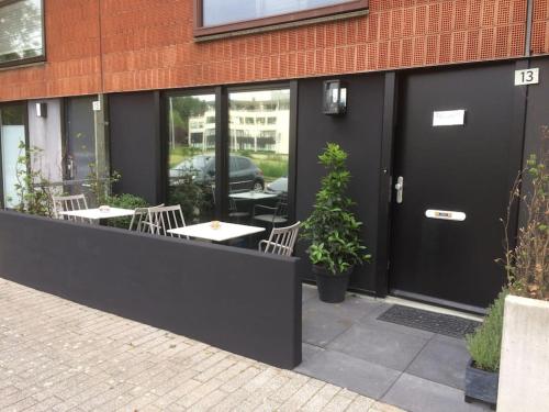 um restaurante com mesas e cadeiras em frente a um edifício em Near Amsterdam and airport, 90m2, privacy! em Hoofddorp