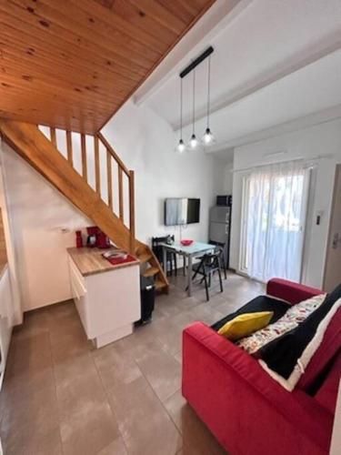 un salon avec un canapé rouge et une table dans l'établissement Appartement 4 couchages, à Balaruc-les-Bains