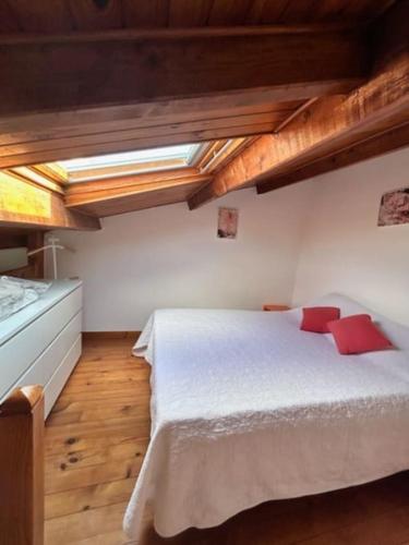 ein Schlafzimmer mit einem großen weißen Bett mit roten Kissen in der Unterkunft appartement 4 couchages in Balaruc-les-Bains