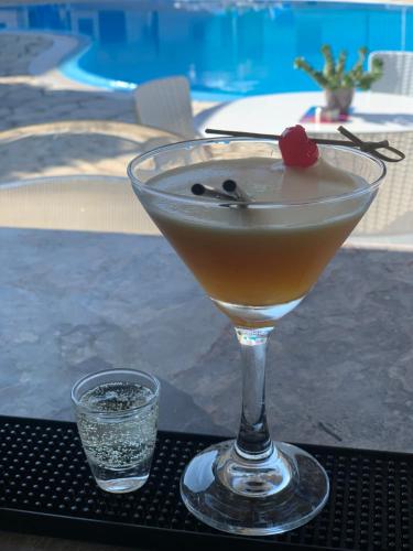 a martini sitting on a table near a pool at Secreta Vista in Kavos