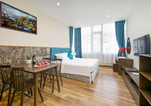 una camera d'albergo con letto, tavolo e sedie di Yuni Hotel And Apartment a Da Nang