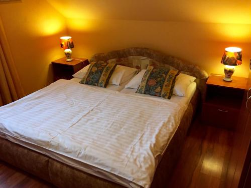 a bedroom with a large white bed with two lamps at Penzion U Golema Blansko in Blansko