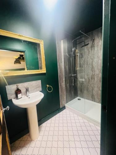 a green bathroom with a sink and a shower at Mollys Boutique Hotel in Ilkley