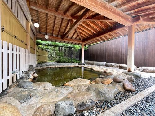 a pool of water in a building with rocks at Shugyoku no Yu Yakushido Onsen in Oshu