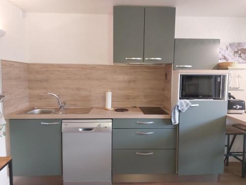 une cuisine avec un réfrigérateur et un micro-ondes dans l'établissement Studio cosy au centre de Vallandry, à 50m des remontées mécaniques - FR-1-411-529, à Landry