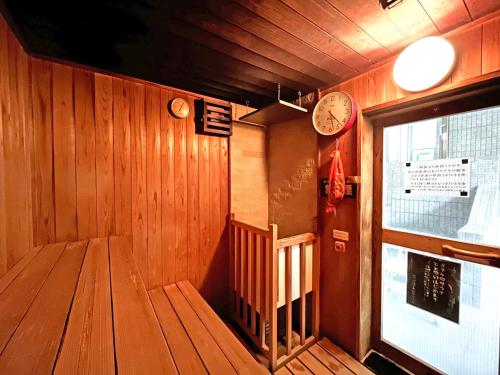 a room with a staircase and clocks on the wall at Shugyoku no Yu Yakushido Onsen in Oshu